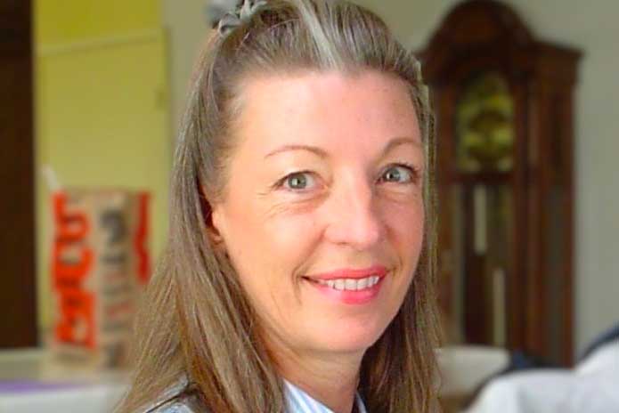 A woman looking into the camera, smiling.