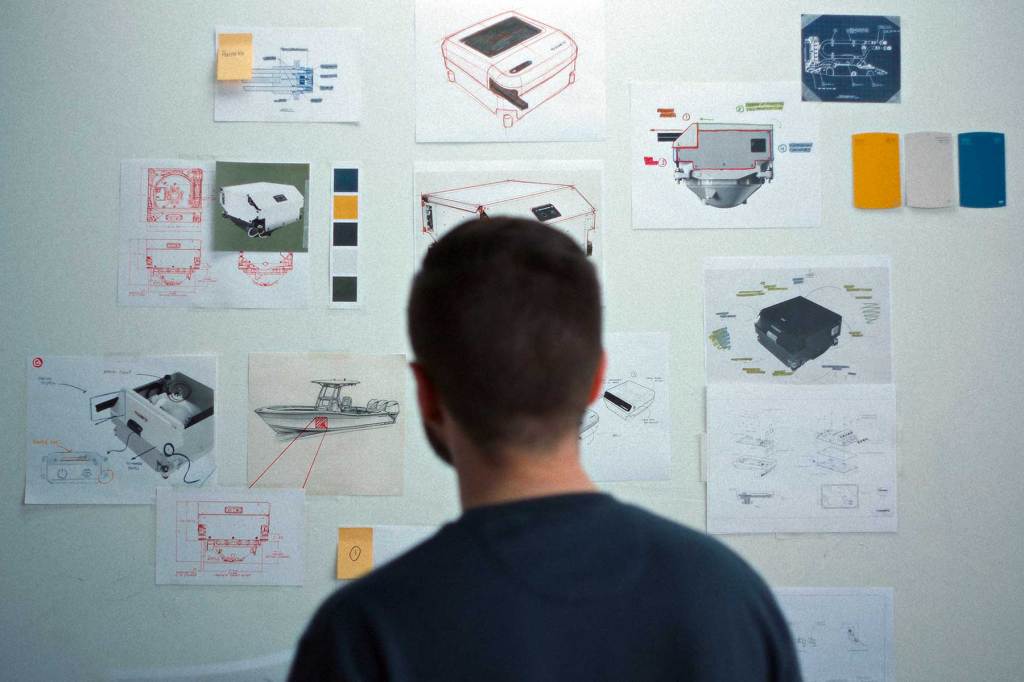 Man standing in front of a whiteboard with notes stuck on it