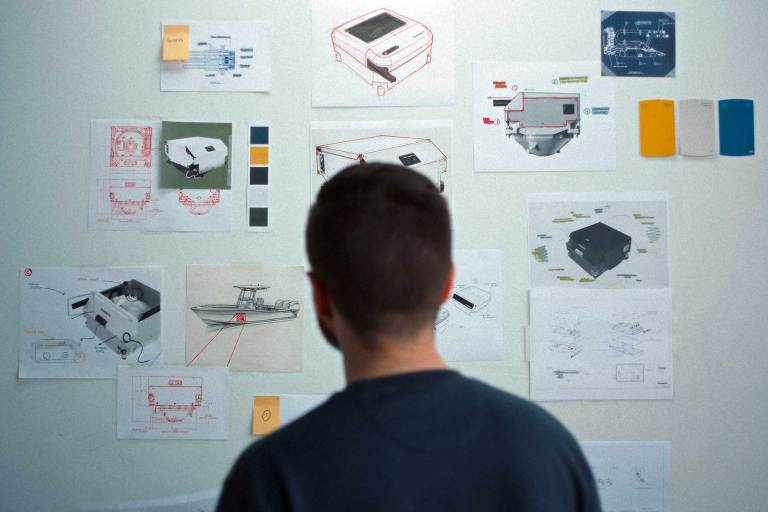 Man standing in front of a whiteboard with notes stuck on it