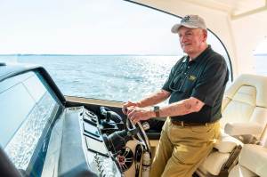 Man in a ball cap driving a boat
