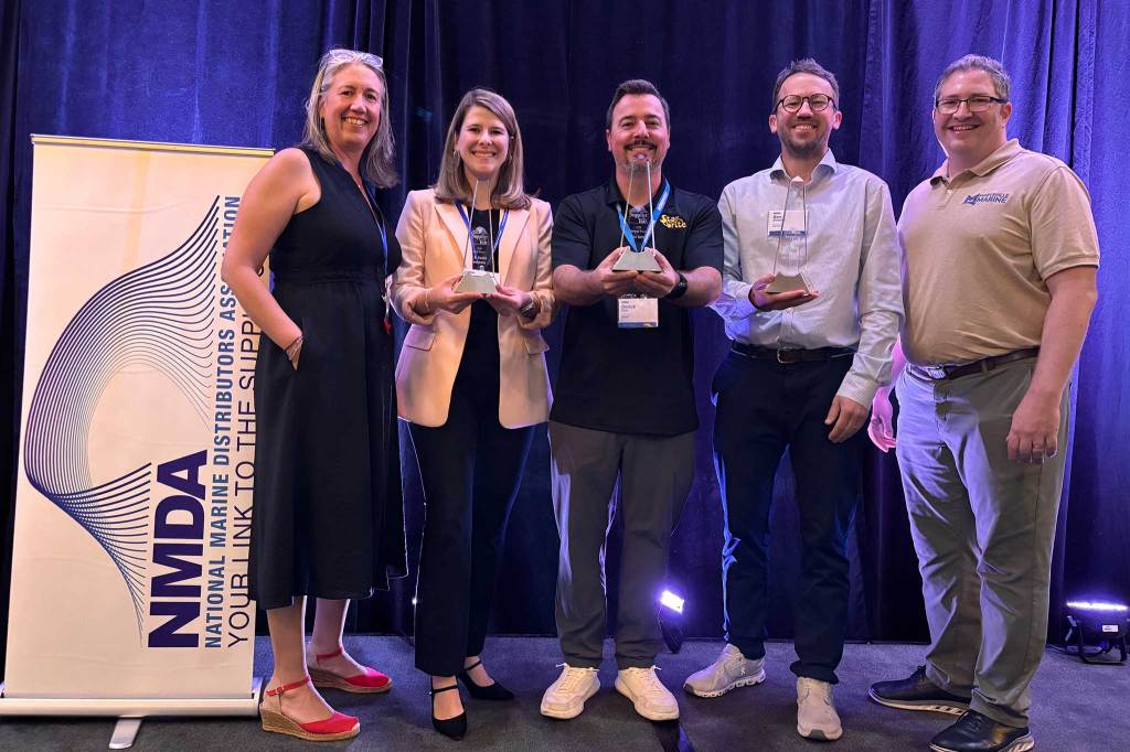 Five award winners standing on a stage smiling for the camera