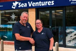 A man and a woman standing out in front of a Sea Ventures' storefront